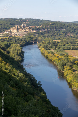  The medieval Chateau de Beynac rising on a limestone cliff above the Dordogne River seen from Castelnaud. France, Dordogne department, Beynac-et-Cazenac