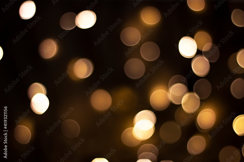 Bokeh. Small gold defocused lights on a dark brown background. Design concept Bokeh. Small gold defocused lights on a dark brown background. Design concept