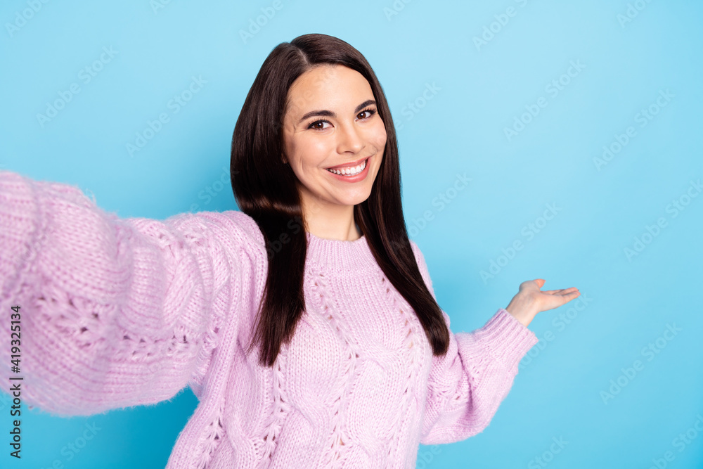 Photo of young woman happy positive smile demonstrate hands welcome invite sign make selfie isolated over blue color background Photo of young woman happy positive smile demonstrate hands welcome invite sign make selfie isolated over blue color background