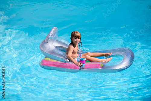 Kids happy summer. Summertime vacation. Child in pool. Boy swimming at swimmingpool. Funny kid on inflatable rubber mattress.