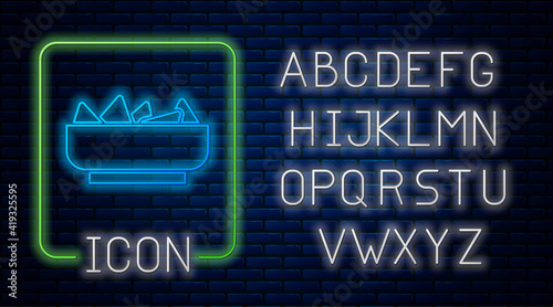 Glowing neon Nachos in bowl icon isolated on brick wall background. Tortilla chips or nachos tortillas. Traditional mexican fast food menu. Neon light alphabet. Vector.