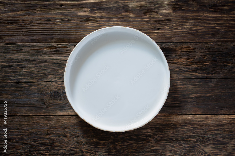 White empty dish on wooden background White empty dish on wooden background