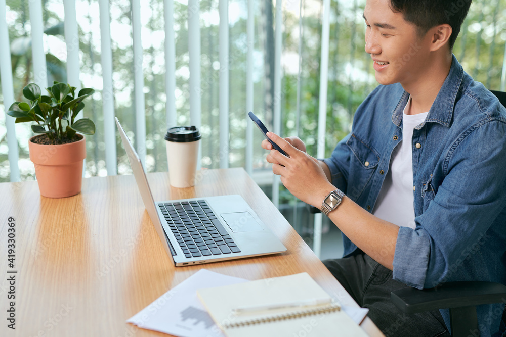 Businessman Using Phone Whilst Working In Coffee Shop Businessman Using Phone Whilst Working In Coffee Shop
