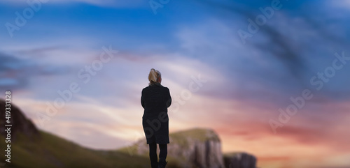 silhouette of a woman walking in mountains.