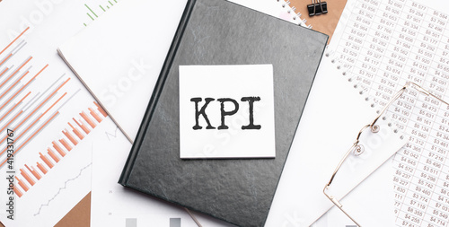 Text KPI on notepad with office tools, pen on financial report . Business and financial conzept. calculator and the working paper with a diagram.