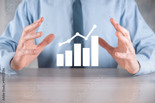 Businessman hold drawing on screen growing graph, arrow of positive growth icon.pointing at creative business chart with upward arrows.Financial, business growth concept