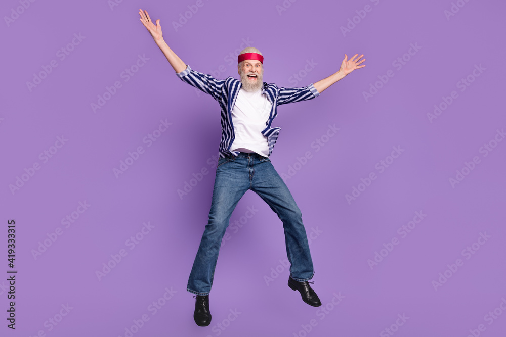 Full length photo of aged excited man happy positive smile jump up have fun isolated over violet color background