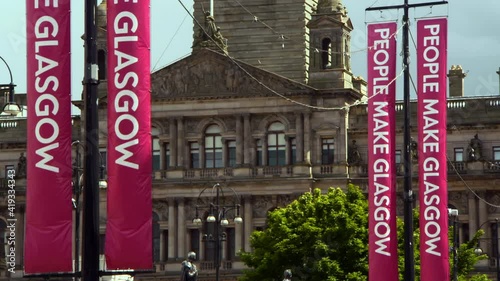 Bright Banners Hang From Telephone Poles Before Magnificent Sandstone Building With Relief Sculptures And Columns photo