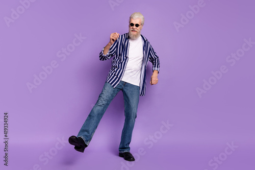 Full body photo of aged man happy positive smile have fun dance music party isolated over purple color background