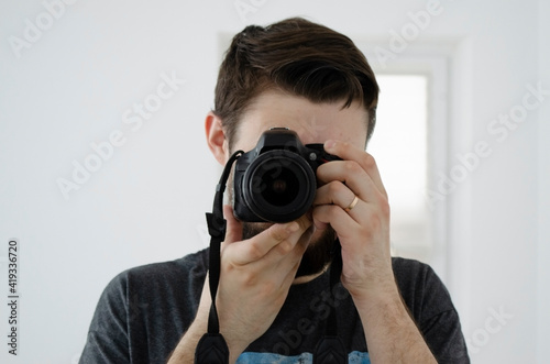 young guy holding a camera in his hands. photographer man