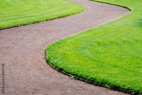 curved footpath in park admist green grass