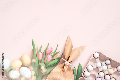 Tender pastel festive Easter background with gift and eggs  decorated with pink tulips