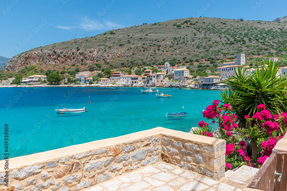 Limeni village with the famous  stone buildings a blooming bougainvillea, and turquoise waters in Mani, South Peloponnese , Greece.