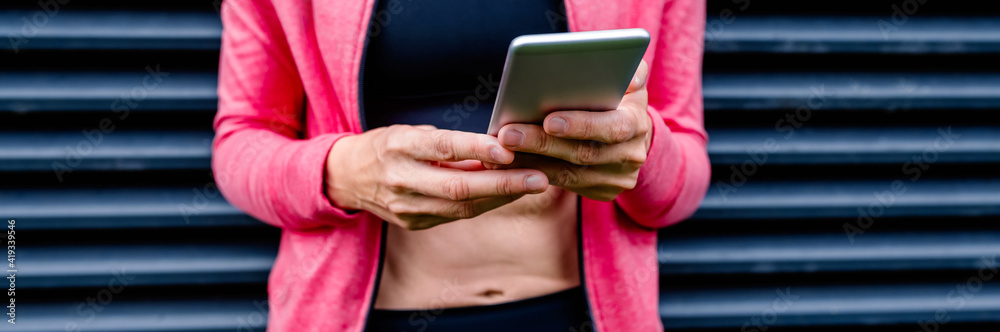 Unrecognizable female athlete with mobile phone Unrecognizable female athlete with mobile phone