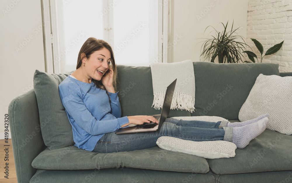 Happy successful young woman on laptop working from home. New normal concept