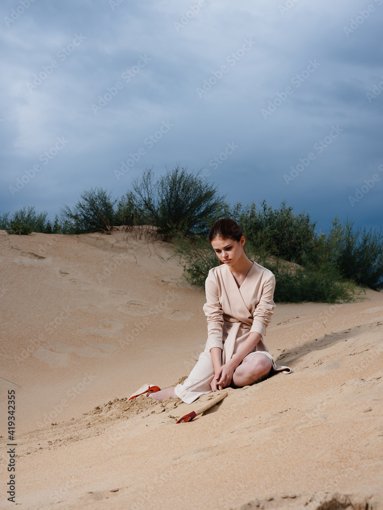 on the sand on a deserted beach a woman with an ax and a sundress