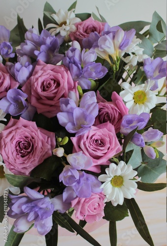Background of flowers, pink roses, white chamomile and blue freesias.