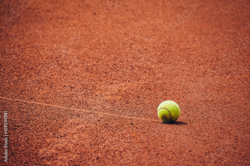 tennis ball rolling over red playground © Stadtrandfoto