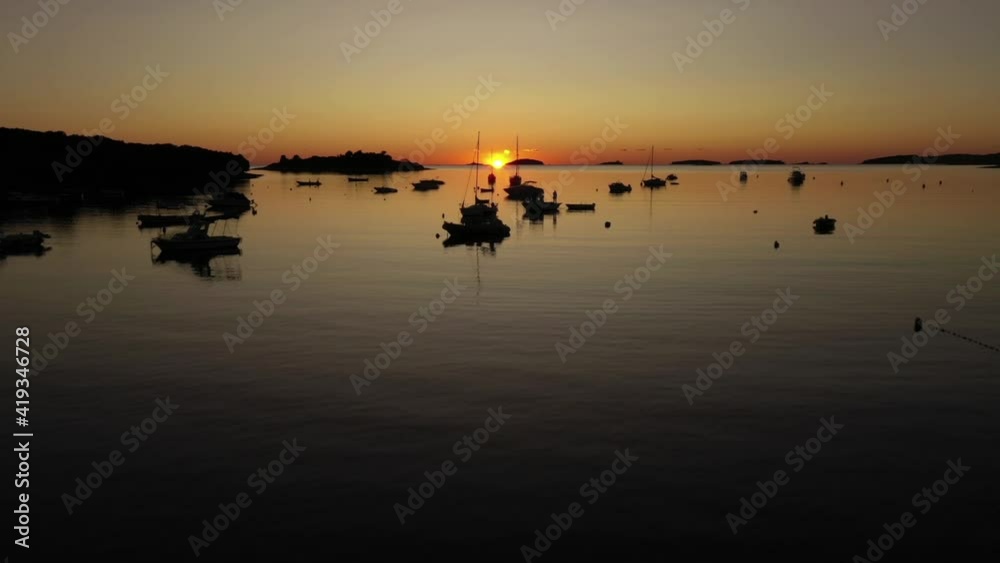 Flying over docked boats in a small bay in Croatia, during sunset Flying over docked boats in a small bay in Croatia, during sunset