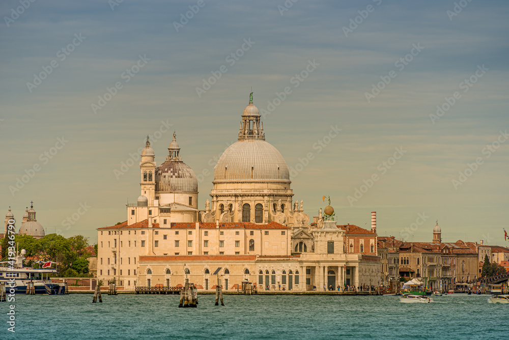 Colorful view of Basilica di Santa Maria della Salute and busy Grand Canal at sunset, Venice, Italy, summer time