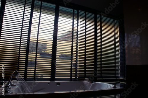 Evening sun light outside wooden window blinds, sunshine and shadow on window blinds , decorative interior home concept