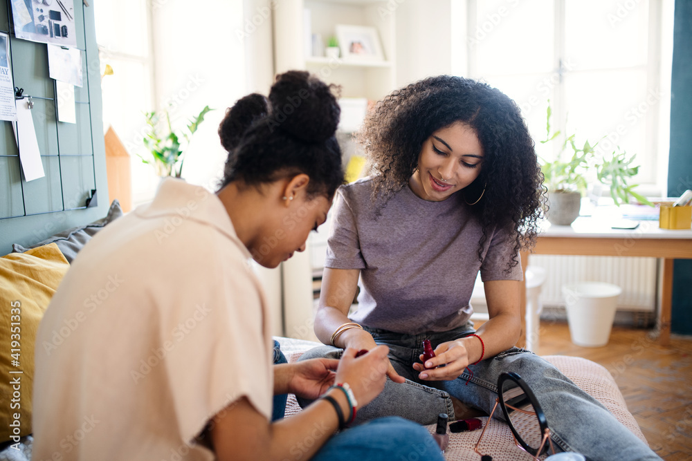 Portrait of young sisters indoors at home, painting nails. Portrait of young sisters indoors at home, painting nails.