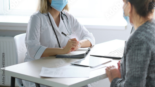 Female professional doctor showing medical test result explaining prescription. Elderly people healthcare tech concept.