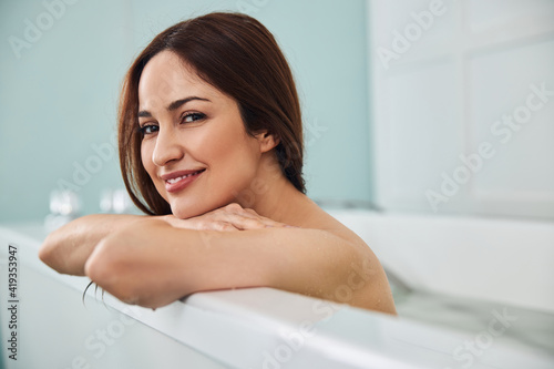 Female with bare shoulders smiling in jacuzzi
