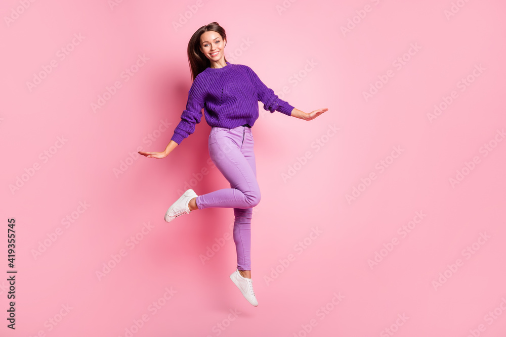 Full size photo of optimistic girl jump dance wear lilac sweater trousers sneakers isolated on pink background