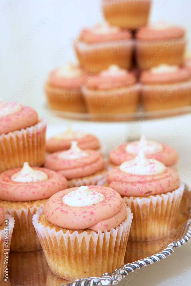  Pink cupcakes decorated with white icing and sprinkles
