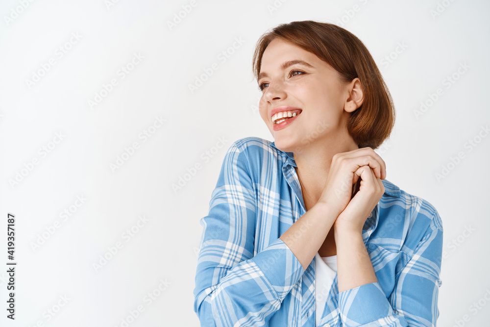 Portrait of cute woman admire something beautiful, looking aside at copy space and smiling tenderly. Girl gazing dreamy at logo, standing on white background Portrait of cute woman admire something beautiful, looking aside at copy space and smiling tenderly. Girl gazing dreamy at logo, standing on white background