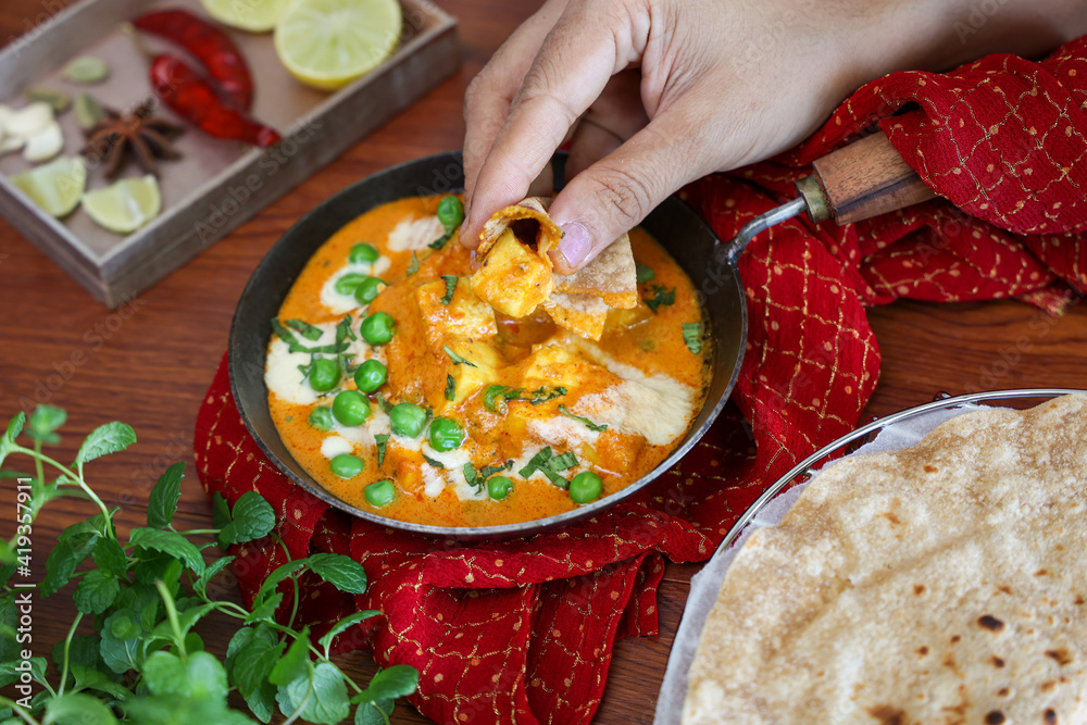 Woman hand eating Matar Paneer curry, paneer butter masala recipe made