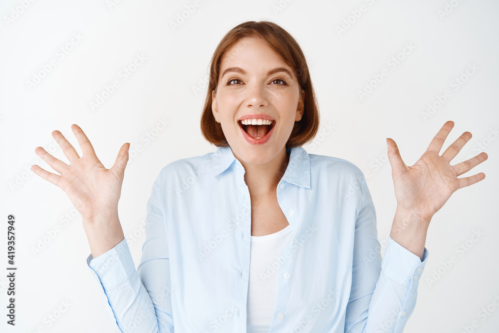 Portrait of excited and enthusiastic woman, spread hands sideways and scream of joy, winning, feeling happy and upbeat, celebrating on white background Portrait of excited and enthusiastic woman, spread hands sideways and scream of joy, winning, feeling happy and upbeat, celebrating on white background