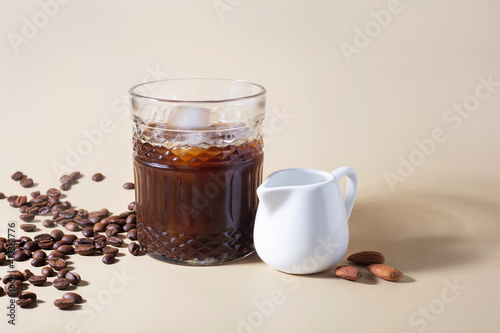 iced coffee with almond milk on a beige background, minimalism, summer drink, shadows