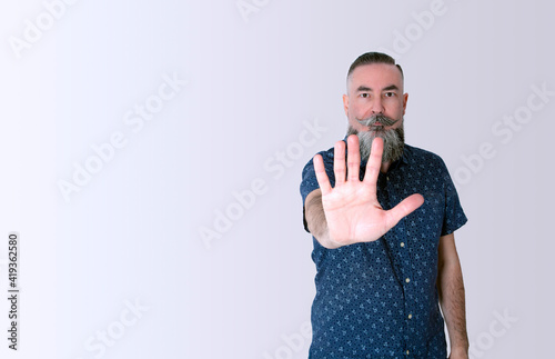 Foto bearded hipster 40-45 years old, reaching out and putting his hand in front of him as a sign of stopping or not letting go