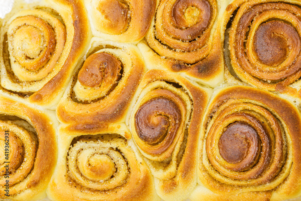 Cinnamon dough bun rolls traditional Danish baked sweet autumn cake holiday dessert swirl bread food close up texture.