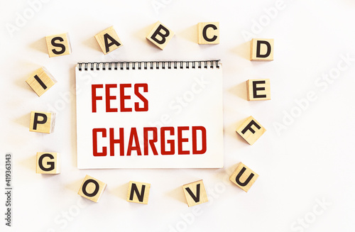 FEES CHARGED - words are written on a notepad and a white background
