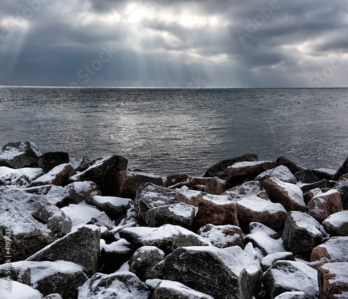 Winter sea landscape. Stones on the shore in the snow and gloomy harsh sea. Odessa. Ukraine. © Ann Stryzhekin