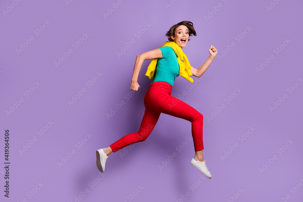 Full length photo of excited lady jump run wear knotted pullover t-shirt pants footwear isolated violet color background