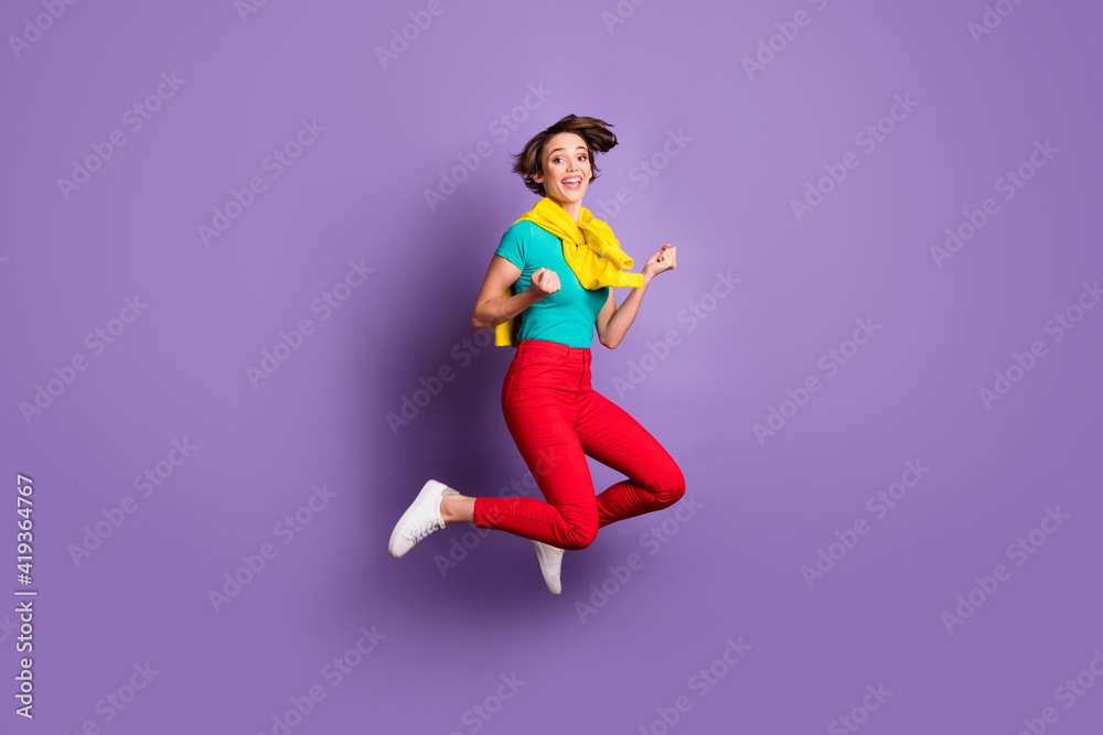 Full length photo of champion girl jump wear tied pullover t-shirt trousers sneakers isolated violet color background