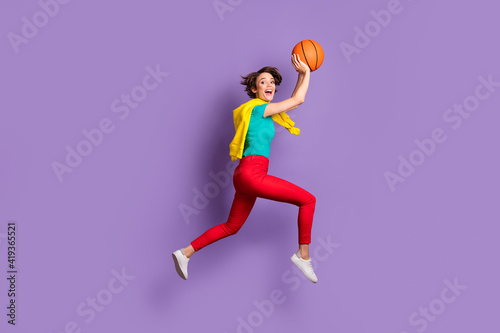 Full length photo of lady jump run throw ball wear tied sweater t-shirt pants footwear isolated violet color background