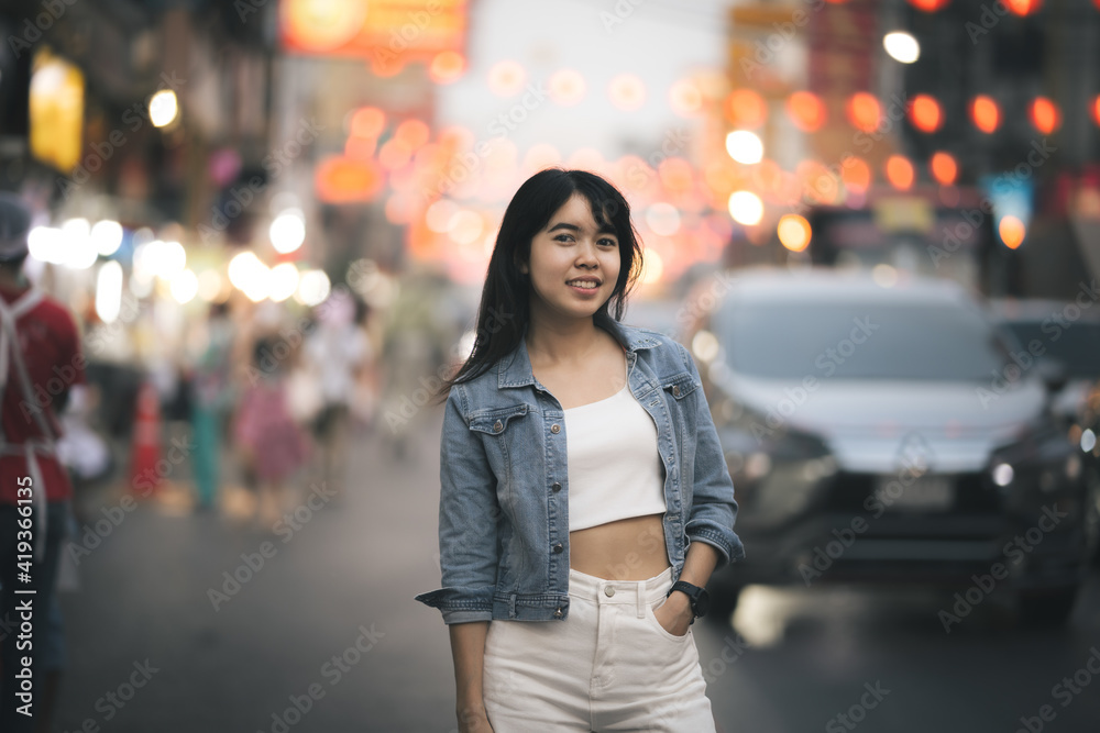 Beautiful Asian woman who has long hair travels to the festival at Yaowarat Chinatown in Thailand. Street photography of traveler woman at night.