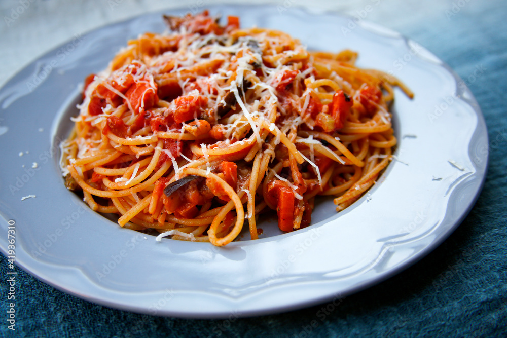 pasta spaghetti with tomato sauce on grey plate