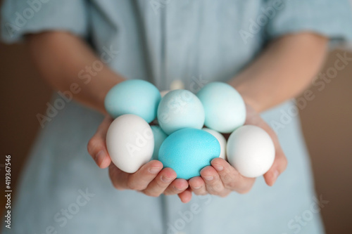 White and blue Easter eggs in thin hands. Soft calm colors, soft light. Selective focus, copy space. Easter concept © Danila Shtantsov
