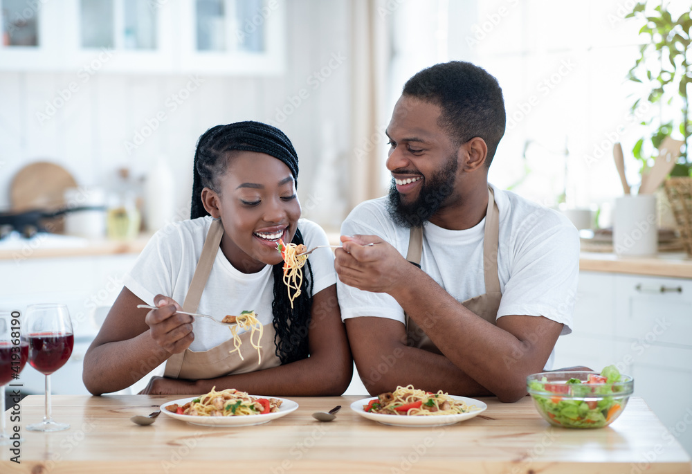 African American Lovers Eating Spaghetti And Drinking Red Wine In Kitchen African American Lovers Eating Spaghetti And Drinking Red Wine In Kitchen