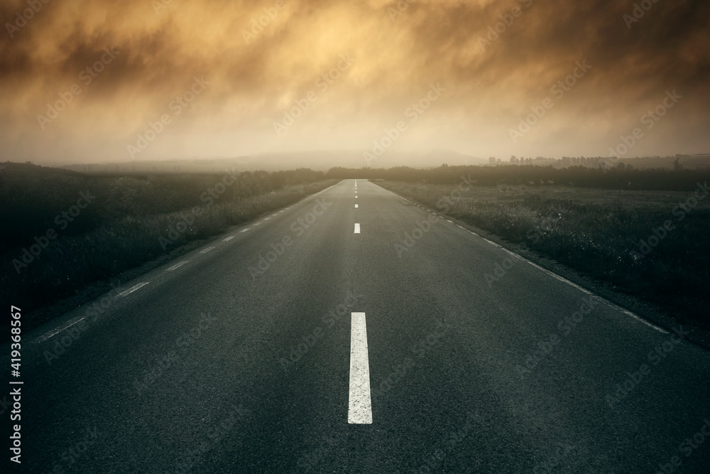 empty road with storm clouds at sunset