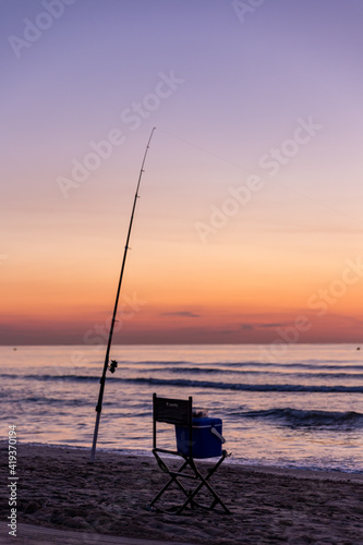 Fishing rod with sunrise and beautiful colors at malvarosa beach of the City of valencia, costa blanca, spain photo