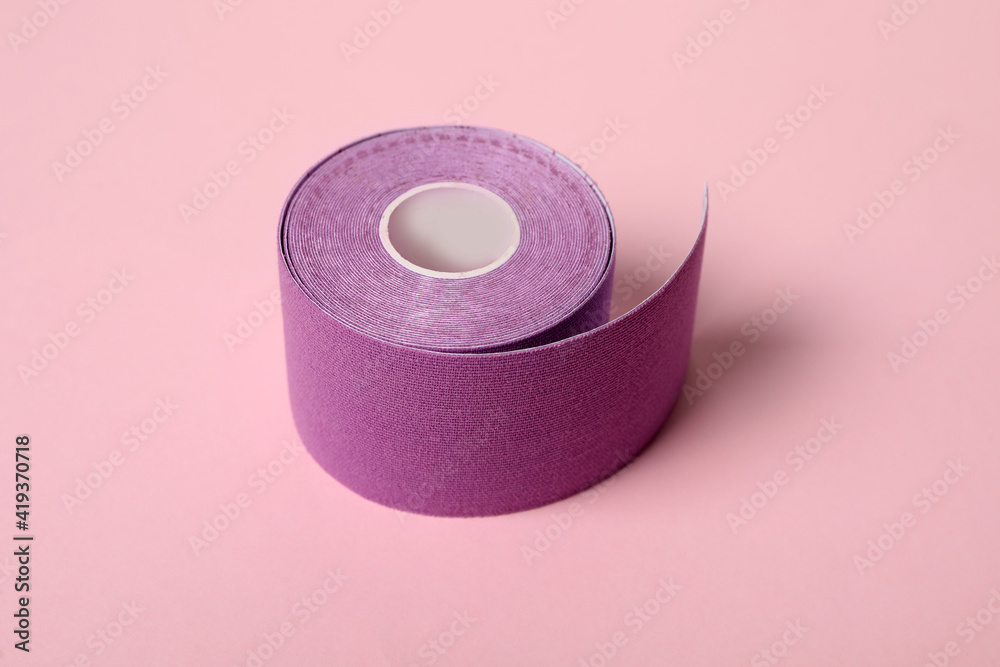Bright kinesio tape in roll on pink background Bright kinesio tape in roll on pink background
