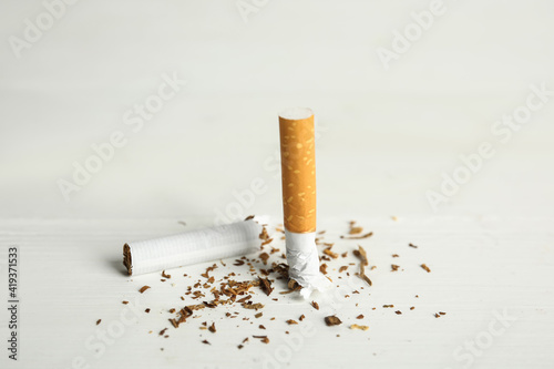 Broken cigarette on white table. Quitting smoking concept