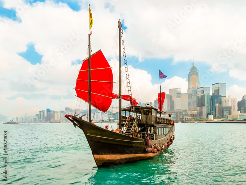  Traditional junk sailboat with red sails in the Victoria harbor, Hong Kong
